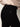 Close-up of a person wearing Sanctuary Clothing's 90s straight legging black pants and a light beige sweater. The pants feature a back pocket with a small "SANCTUARY" label; the person is turned slightly to the side.