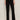 A person stands against a plain wall wearing Sanctuary Clothing’s marine ponte pant in black with black open-toe heels. Their arms are relaxed by their sides, and only their body from the shoulders down is visible.