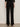 A person stands facing a light wall, wearing the Sanctuary Clothing marine ponte pant in black with black heeled shoes. The photo, taken from behind, highlights the back pockets and straight fit of these high-waisted, wide-leg pants.
