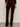 A person stands facing away, wearing Sanctuary Clothing's velveteen brook bootcut pant in dark crimson petites with wide legs and large back pockets, paired with a matching sweater and black heeled shoes.