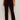A person stands against a plain light wall, hands relaxed, wearing Sanctuary Clothing's velveteen brook bootcut pant in dark crimson (extended sizing) paired with black boots.