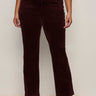 A person stands against a plain light wall, hands relaxed, wearing Sanctuary Clothing's velveteen brook bootcut pant in dark crimson (extended sizing) paired with black boots.