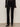 Wearing Sanctuary Clothing's velveteen brook bootcut pant in black with a black, flared-cuff long-sleeve top and black ankle boots, the person stands against a plain light wall, shown from shoulders to feet.