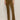 A person wearing Sanctuary Clothing's velveteen brook bootcut pant in dirty martini, paired with black heeled boots, stands against a light wall. Their upper body is mostly out of frame.