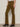 A person wears Sanctuary Clothing's velveteen brook bootcut pant in dirty martini, styled with a white top and black heeled ankle boots, standing against a light background.