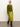A woman in Sanctuary Clothing’s everyday midi skirt martini olive, a green cardigan, and black heeled boots stands against a plain background, gazing confidently to the side.