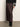 A person wears the Sanctuary Clothing everyday maxi skirt semi sweet, paired with black heeled boots and a black sweater with white patterned cuffs, standing against a light wall and concrete floor.