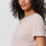A woman with curly dark hair wears the Sanctuary Clothing perfect tee remix vapor rose, paired with a gold necklace, as she poses confidently against a plain light background.