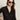A woman with long brown hair, large sunglasses, and gold hoop earrings wears the Sanctuary Clothing dreamgirl lace button up black shirt, posing with one hand on her hip against a plain background.