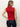 A woman with blonde hair in a low ponytail stands with her back to the camera, wearing the Sanctuary Clothing sleeveless zip mock top in red energy black stripe and dark blue jeans, her left hand resting on her hip.