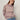 A person wearing the Sanctuary Clothing fairisle crew neck sweater in twilight mauve multi stands against a plain off-white background, paired with tinted sunglasses, light blue jeans, and a gray belt.