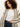 A woman with curly hair wears the Sanctuary Clothing openwork beach cardi in chalk black stripe over a white t-shirt and denim jeans, standing against a plain light background.