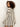Wearing the Sanctuary Clothing openwork beach cardi in chalk black stripe, a person with curly hair looks over their shoulder against a plain light background.