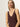 A woman with straight blonde hair models the Sanctuary Clothing v neck knitwear tank mesa, a sleeveless deep V-neck brown top, paired with gold hoop earrings. She stands against a light background and gazes confidently at the camera.