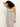 A woman with curly hair poses against a plain light background wearing Sanctuary Clothing’s starlit rib maxi light oat black 3—a sleeveless, form-fitting white dress with horizontal black stripes—one arm raised and bent above her head, gazing downward.