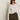 A woman in Sanctuary Clothing's textured raglan crew in white light oat stripe (extended sizing) and high-waisted olive green pants stands against a plain light-colored background.