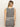 A woman with straight blonde hair is seen from the back in Sanctuary Clothing's city summer tank black macrame stripe 2, a sleeveless black and white striped dress, against a plain light background.