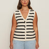 A woman with long brown hair wears the Sanctuary Clothing textured sweater vest macrame black stripe 4, a sleeveless V-neck knit top with black and white stripes, paired with light blue jeans against a plain light background.