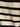 Close-up of the textured sweater vest macrame black stripe 3 by Sanctuary Clothing, highlighting its ribbed fabric with horizontal black and off-white stripes and detailed stitching.