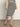 A woman wears the Sanctuary Clothing side slit midi black macrame stripe 2 skirt with a matching top and black sandals, standing on a gray floor against a plain light background.