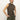 A person with light hair tied back wears the fuzzy shell french kitty sleeveless, high-neck leopard print top from Sanctuary Clothing and olive green pants, standing against a plain white background with hands in pockets.