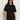 A woman with long dark hair wears black sunglasses and the perfect sweater tee in black by Sanctuary Clothing, paired with black pants, standing against a plain light background.