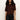 A woman with long curly hair wears the Sanctuary Clothing perfect sweater tee in chicory and black pants, standing against a plain light background.