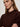 A woman with light brown hair and silver hoop earrings stands with her arms crossed, wearing the Sanctuary Clothing perfect sweater tee in dark crimson, gazing slightly to the side with a neutral expression.