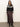 A woman with loose brown hair and a neutral expression stands against a plain background wearing the Sanctuary Clothing fairisle crewneck cardi in ink multi, paired with a long brown satin skirt and black heeled boots.