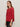 A woman with straight brown hair wears the Sanctuary Clothing ribbed sweater tee in cherry lacquer and black leather pants, standing against a plain light-colored wall.