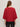 A person with long brown hair stands with their back to the camera in a ribbed sweater tee in cherry lacquer by Sanctuary Clothing, paired with black pants against a plain light background.