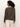 A woman with curly hair is seen from behind wearing the Sanctuary Clothing 24 7 popover french kitty top, featuring a leopard print, with light-colored pants against a plain white background.