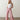 A woman with long blonde hair wears the Sanctuary Clothing marine full length semi high rise pant in galley stripe and a sleeveless white top, standing on a polished concrete floor against a plain light-colored wall.