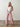 A woman with long blonde hair wears the Sanctuary Clothing marine full length semi high rise pant in galley stripe and a sleeveless white top, standing on a polished concrete floor against a plain light-colored wall.