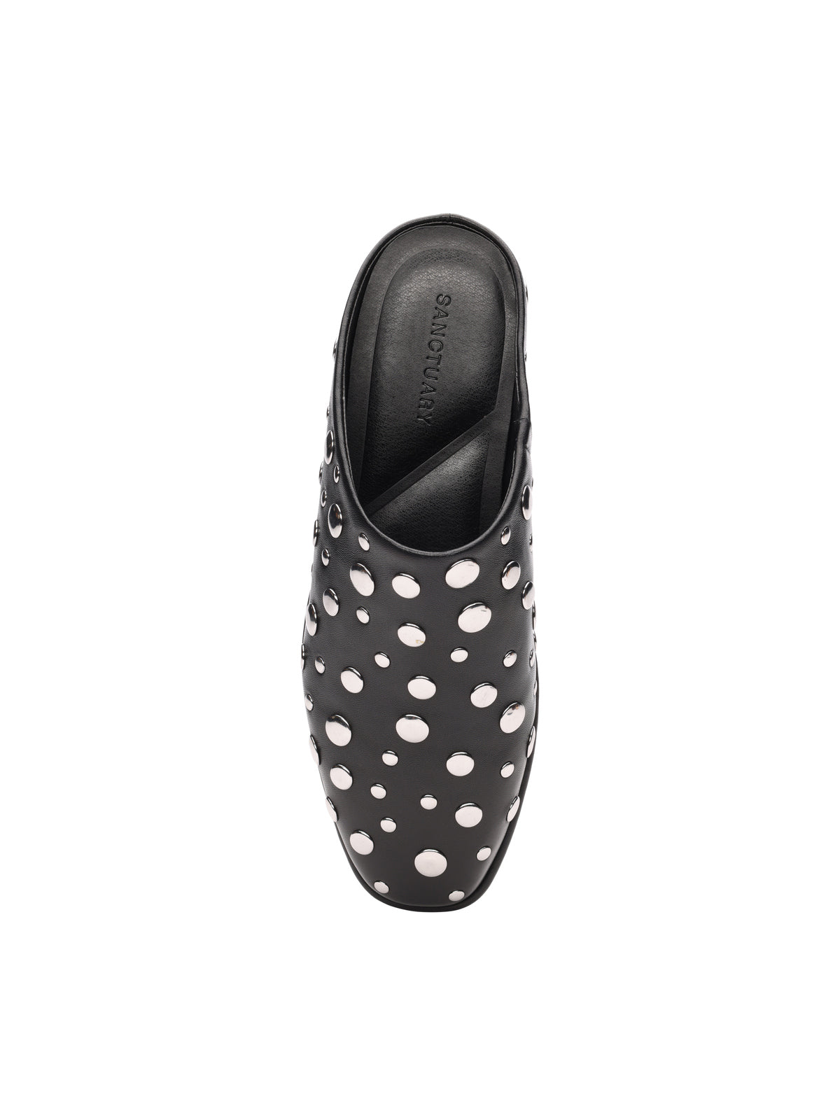 The bari studs mule black by Sanctuary Clothing is a closed-toe black slip-on with white polka dots, a black insole, and “Sanctuary Clothing” printed inside. The shoe is shown from above on a white background.