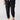 A person is wearing The Harmony Black cargo pants with elasticated cuffs from Sanctuary Clothing, standing with one hand in their pocket. They are also wearing black slide sandals featuring block heels and a white top tied at the waist. The background is plain and neutral.